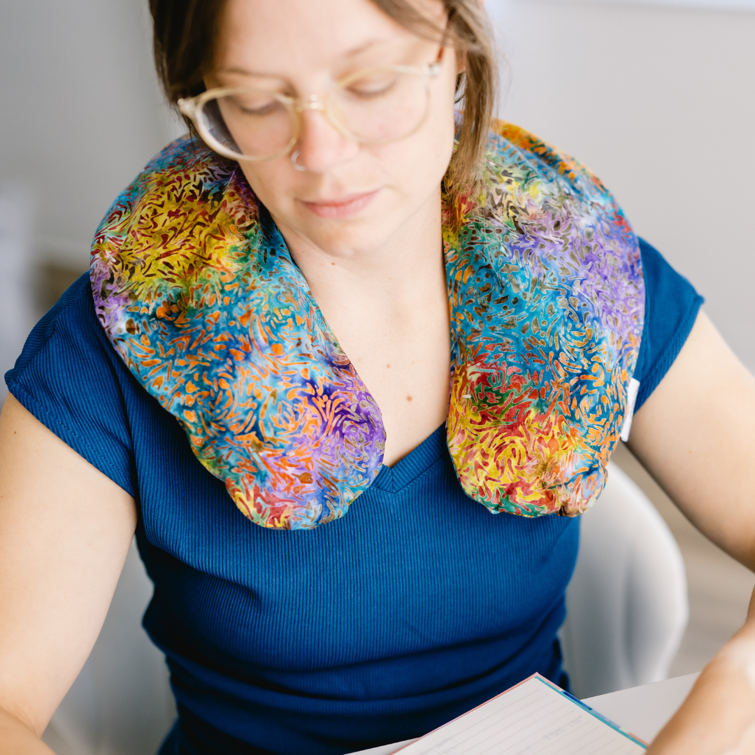 A person wearing a leopard print U-shaped pillow around the neck.